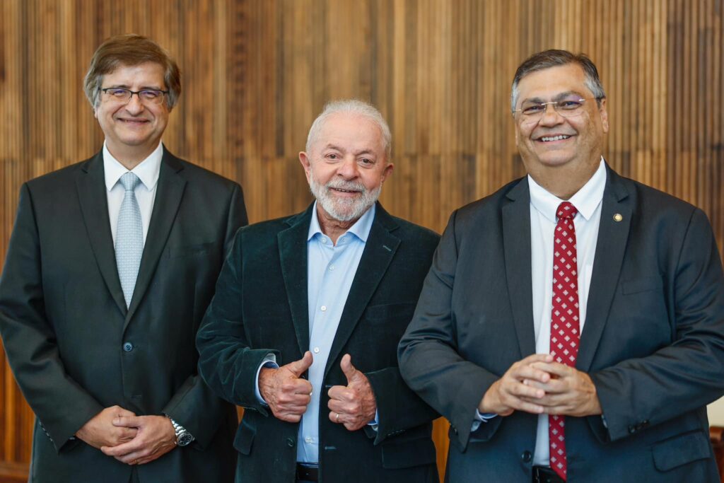 O presidente  Luiz Inácio Lula da Silva (PT) entre os indicados para o cargo da PGR, Paulo Gonet (E), e o ministro da Justiça, Flávio Dino (D), que foi indicado para o STF. Foto: Ricardo Stuckert/PR
