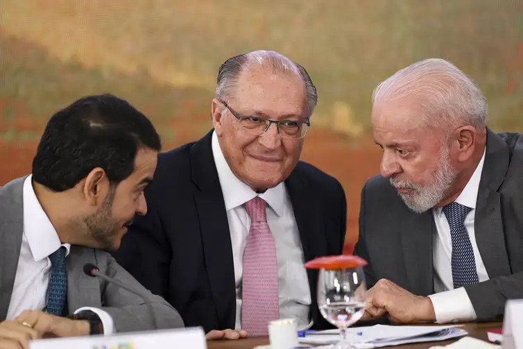 O advogado-geral da União, Jorge Messias, o vice-presidente Geraldo Alckmin e o presidente Lula durante a cerimônia de assinatura de acordo de repactuação da reparação dos danos da tragédia de Mariana